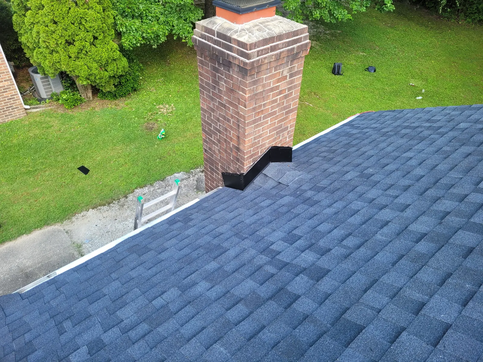 New flashing worked in around a chimney with fresh shingles around it