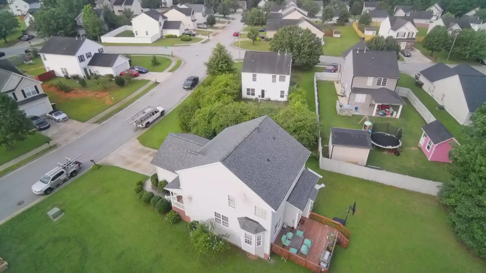 Drone view of the crew trucks and ladders set up on tear off day in a Triad neighborhood