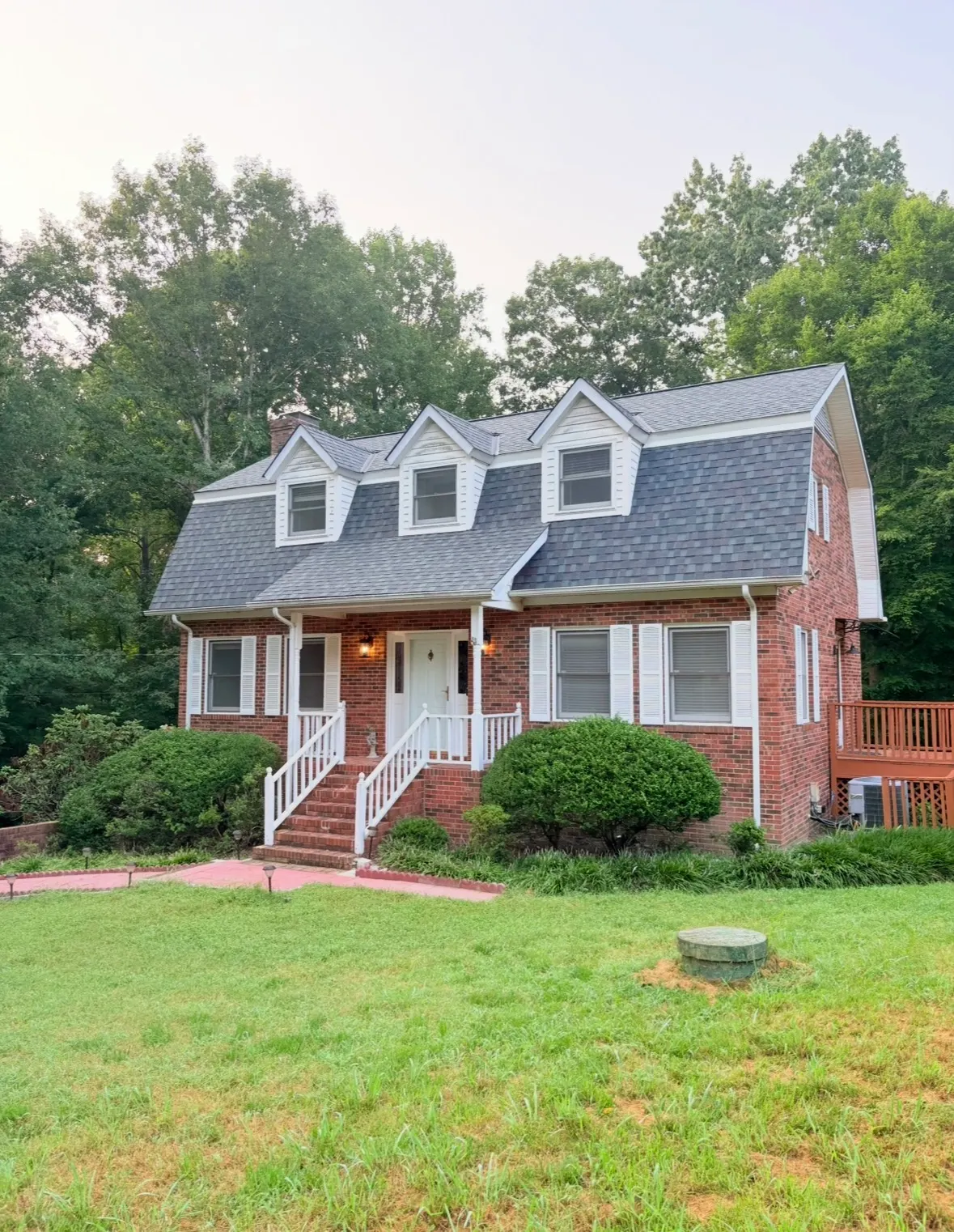 Brick colonial with a new gray shingle gambrel roof and three dormers