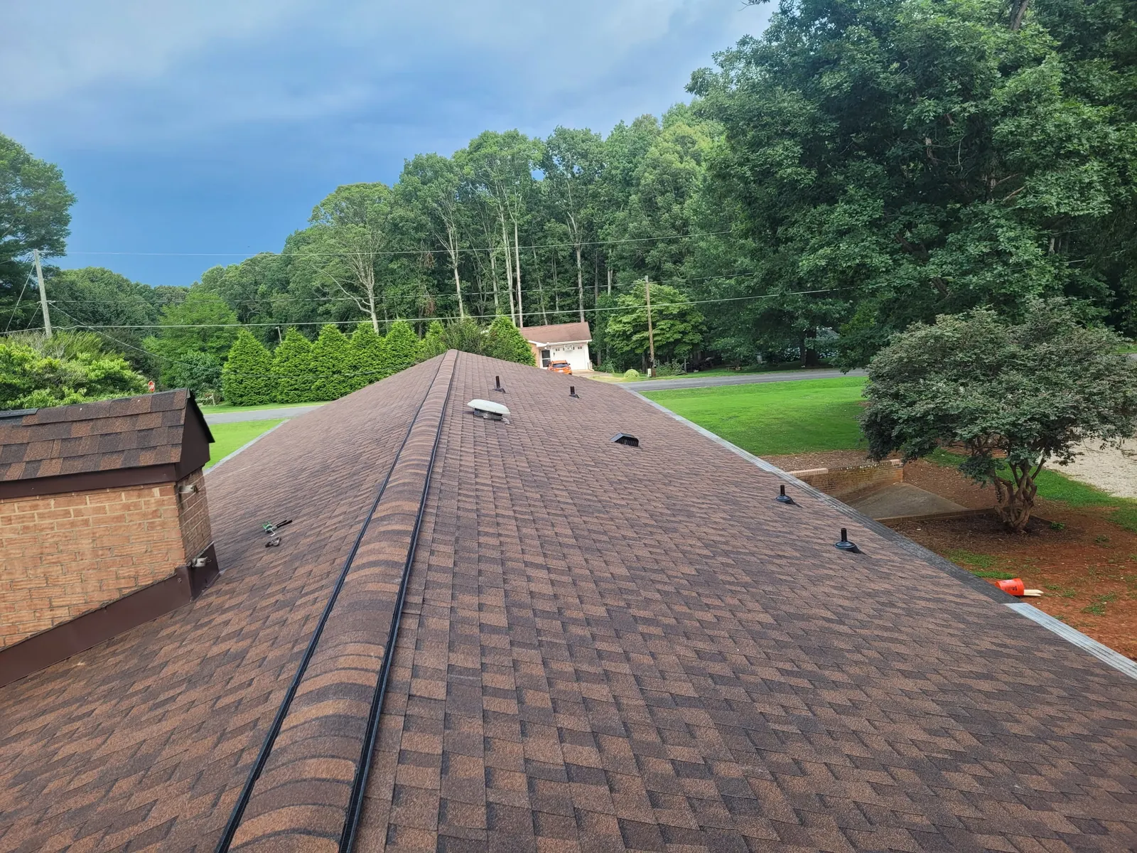 Straight new ridge line on a hickory brown shingle roof