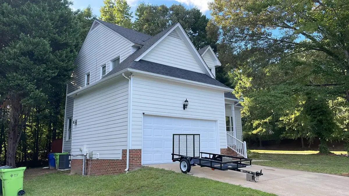 White two story house with its finished new roof and gutters back on