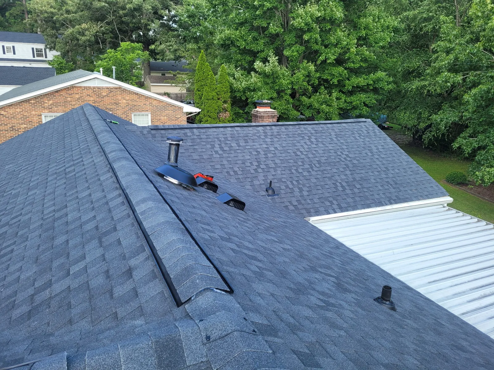 New ridge vent, pipe boots and vents on a finished slate gray roof
